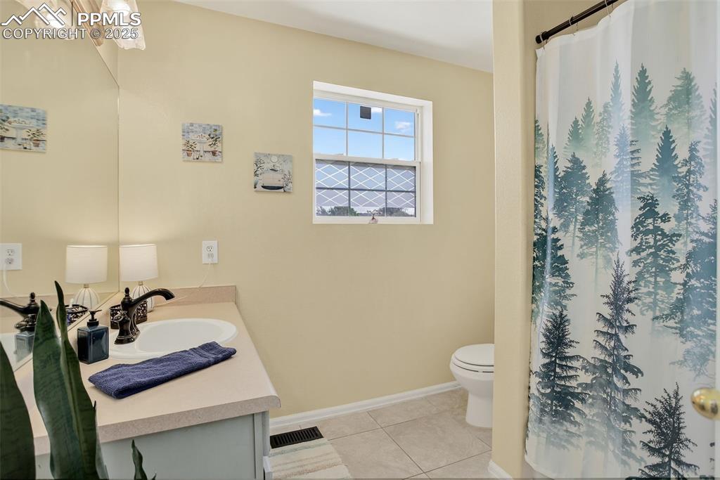 Image 20 of 26: Full bathroom with vanity, tile patterned floors, and a shower with curtain