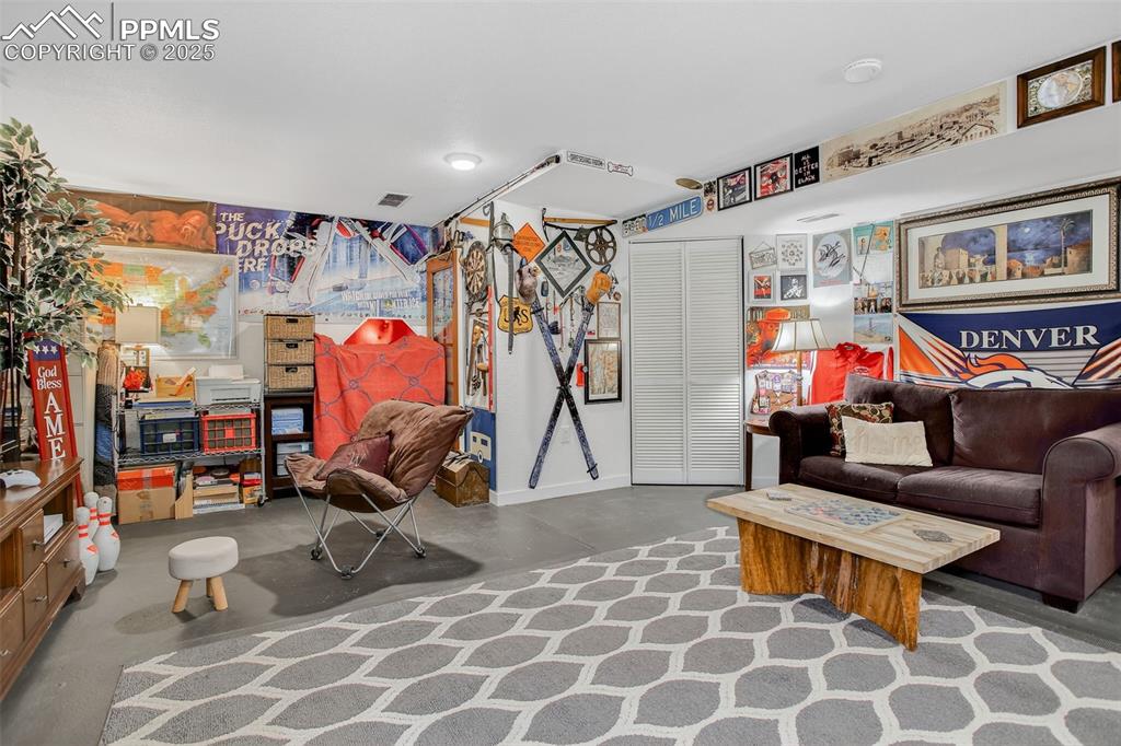 Image 23 of 26: Living area with concrete floors