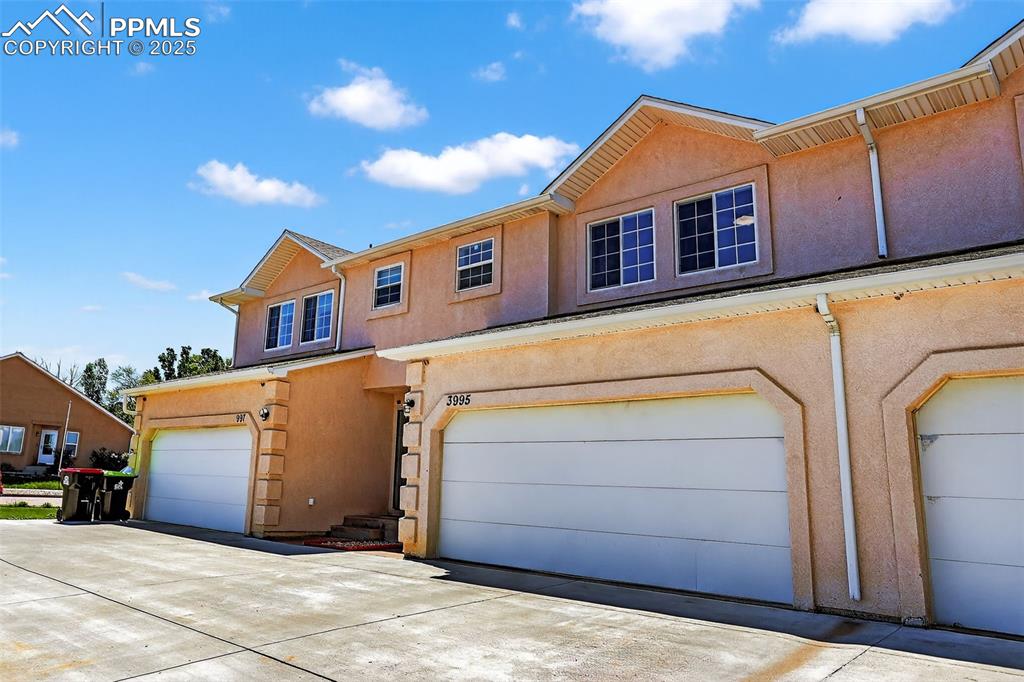 Image 3 of 26: View of property featuring stucco siding and a garage