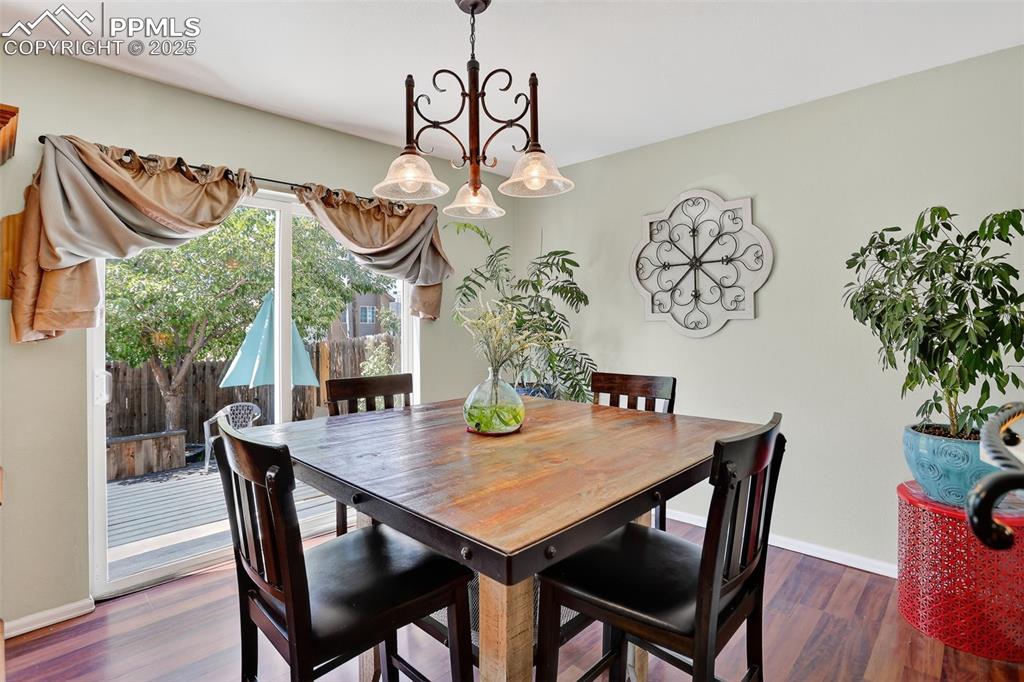 Image 5 of 26: Dining room featuring wood finished floors and a chandelier
