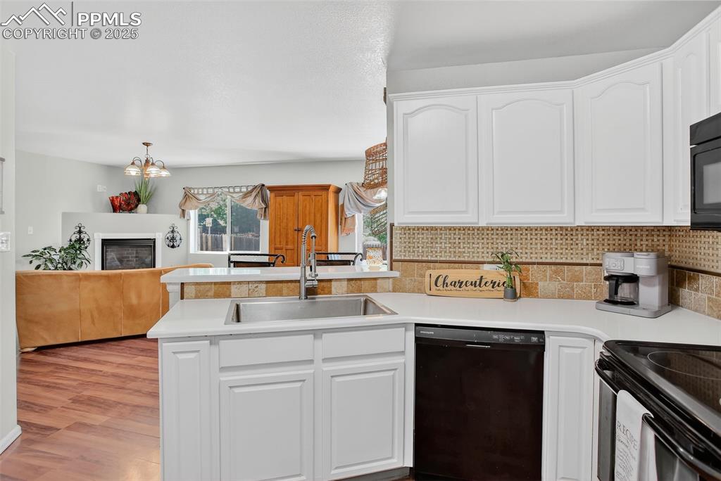 Image 9 of 26: kitchen with white cabinetry, a peninsula, and tasteful backsplash, farm si