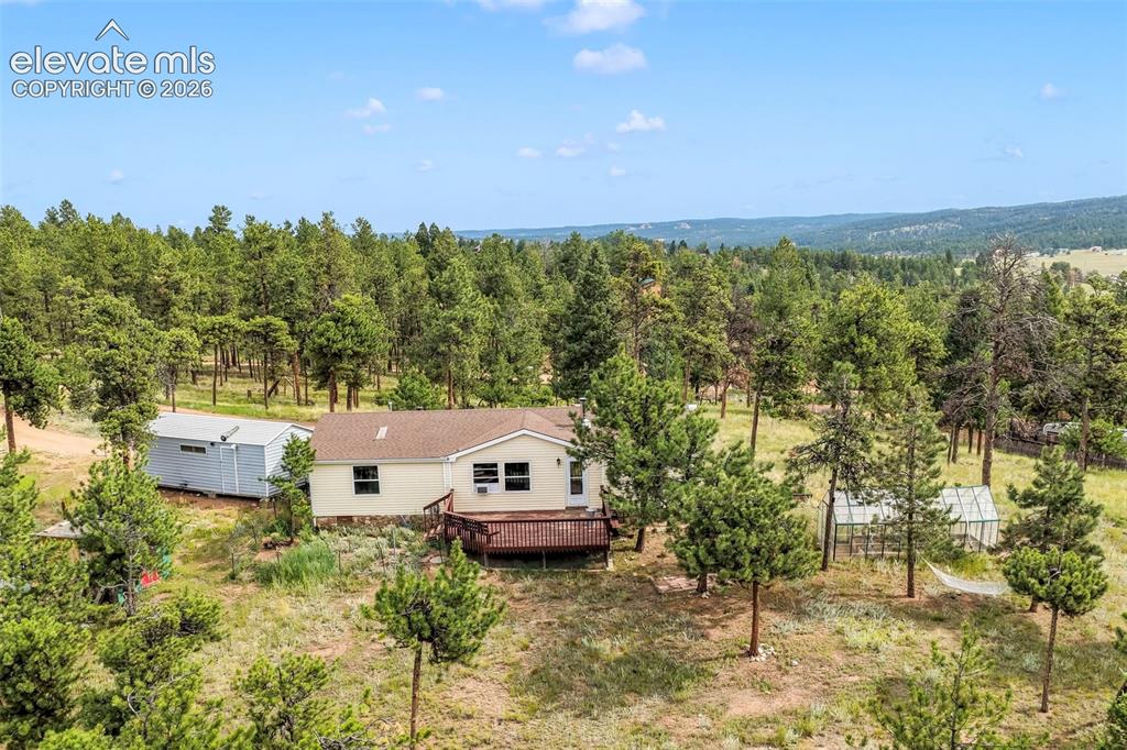 Image 1 of 50: Aerial view of property and surrounding area featuring a forest and mountai