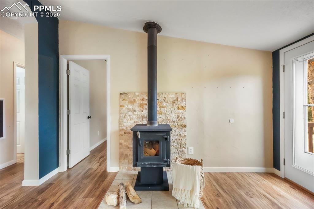 Image 20 of 50: Detailed view of a wood stove and wood finished floors