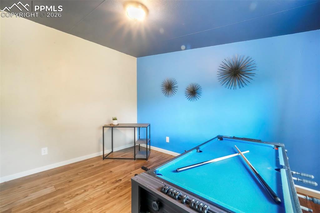 Image 31 of 50: Game room featuring baseboards and wood finished floors