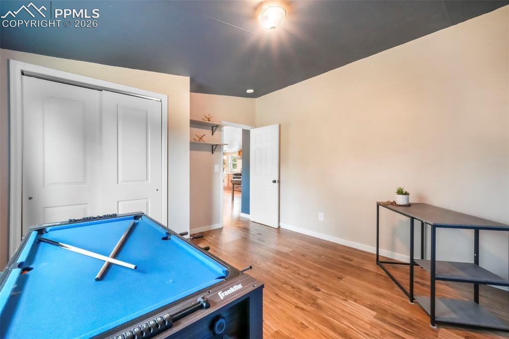 Image 32 of 50: Game room featuring baseboards and wood finished floors