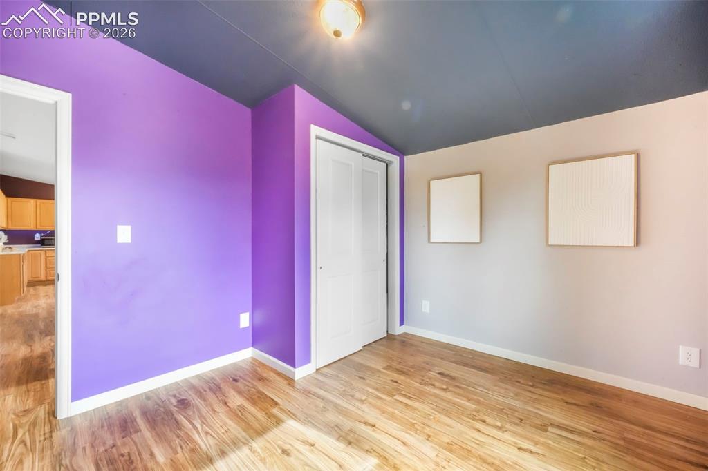 Image 35 of 50: Empty room featuring wood finished floors and lofted ceiling