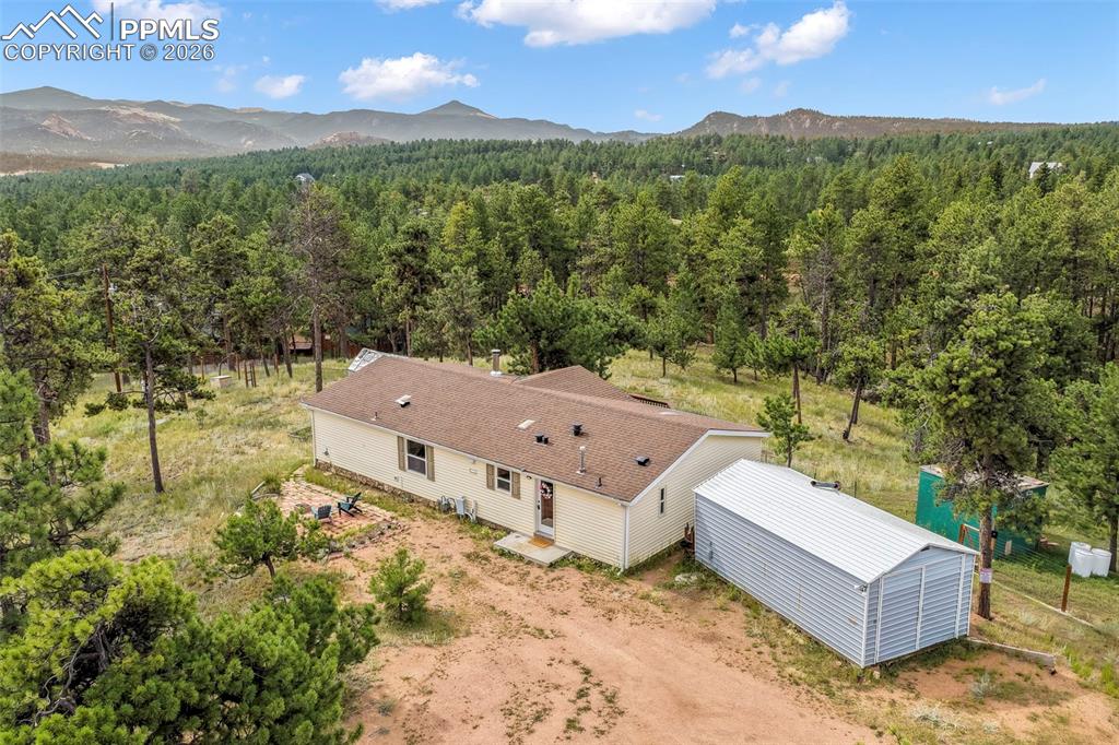 Image 40 of 50: Aerial view of property and surrounding area featuring a forest and mountai