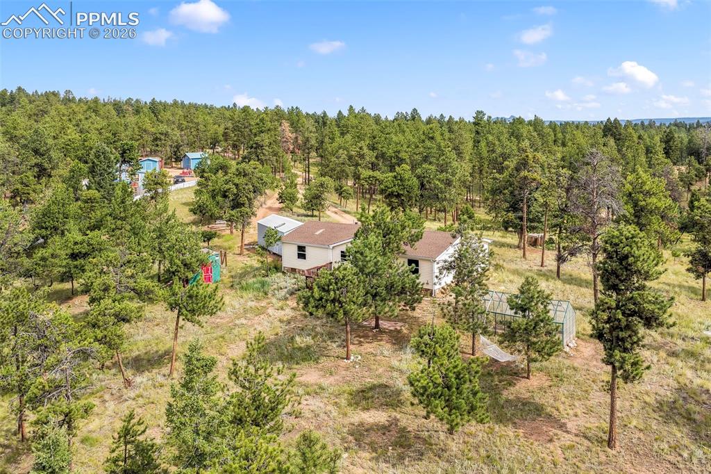Image 47 of 50: Aerial view of property and surrounding area with a heavily wooded area