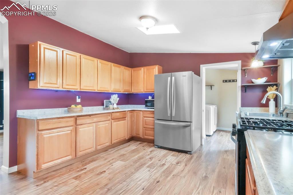 Image 7 of 50: Kitchen featuring stainless steel appliances, light brown cabinetry, light 