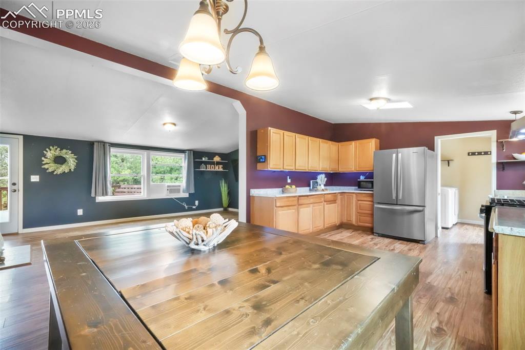 Image 9 of 50: Kitchen with open shelves, stainless steel appliances, vaulted ceiling, lig