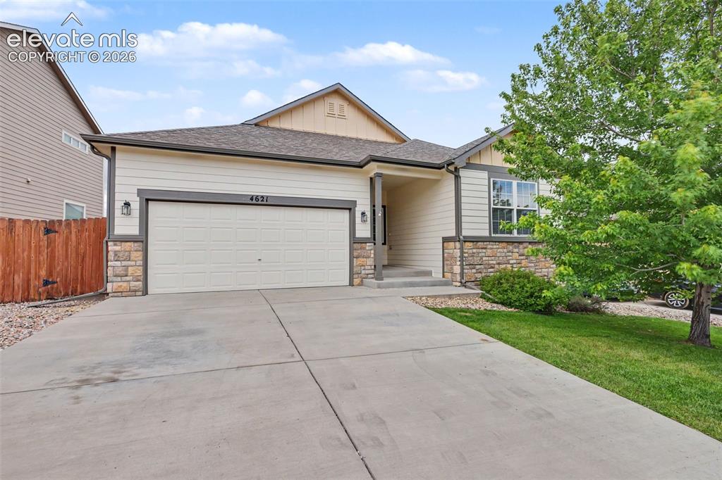 Caption: Single-story residence featuring a two-car garage, stone facade accents, and a concrete driveway