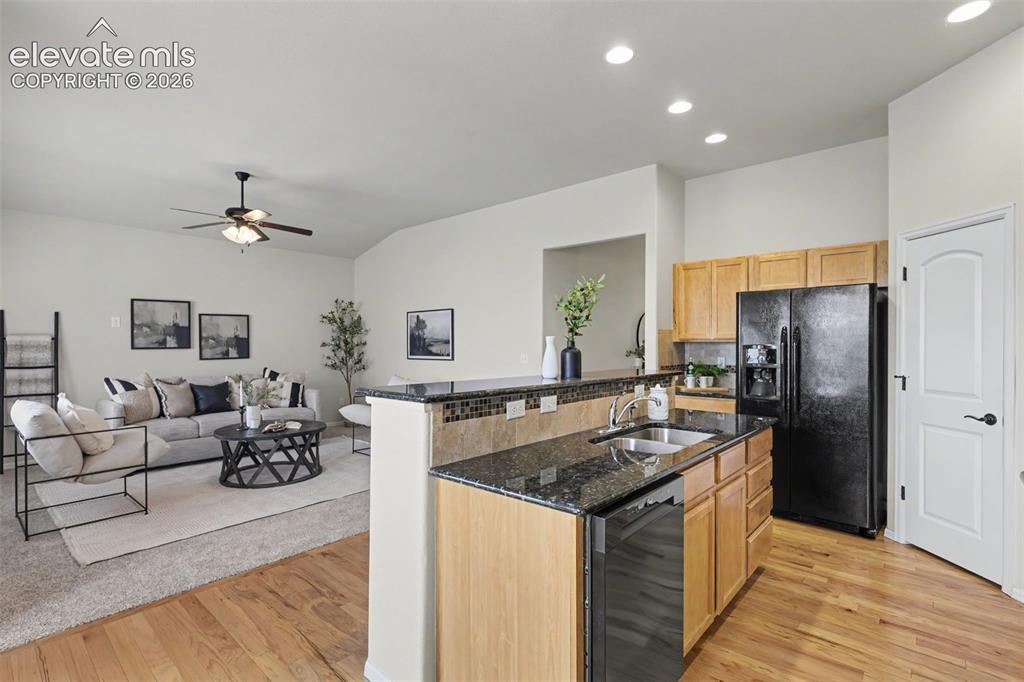 Image 12 of 39: Open-concept living area featuring wood-finish flooring, a kitchen island w