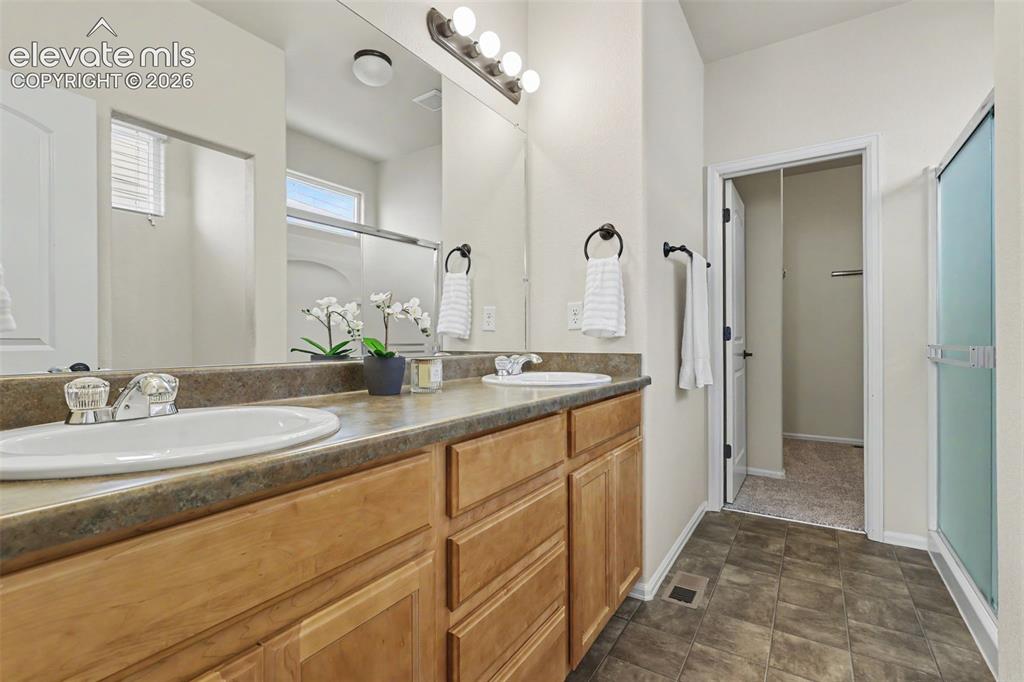Image 22 of 39: Dual vanity with laminate countertop, integrated sinks, wood-finish cabinet