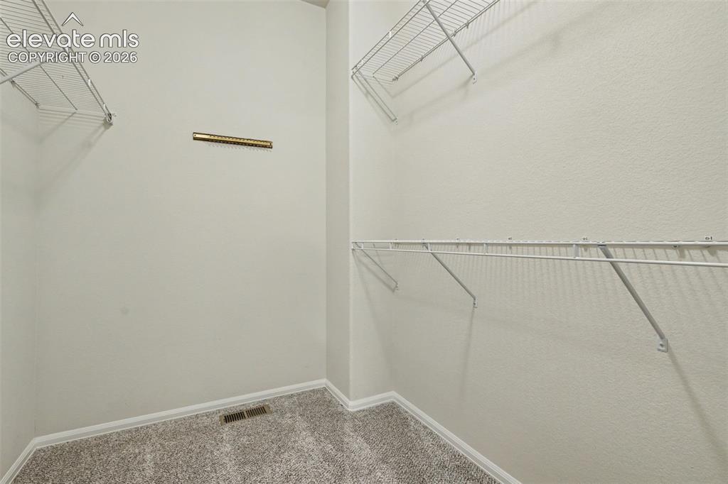 Image 24 of 39: Walk-in closet featuring light-colored walls, wire shelving, and neutral-to