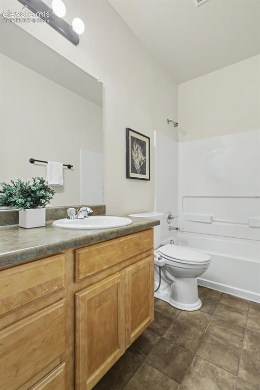 Image 27 of 39: Bathroom vanity with light wood-finish cabinetry, a built-in sink, and a da