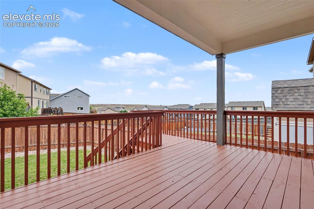 Image 35 of 39: Expansive covered deck featuring rich wood-finish flooring and railing
