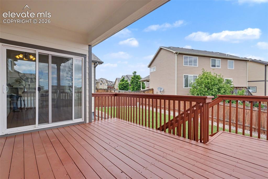 Image 36 of 39: Spacious covered deck featuring rich wood-finish flooring, a full-height ra