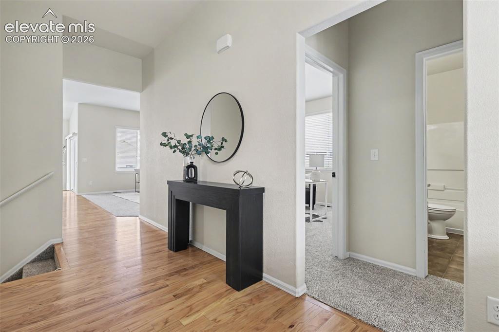 Image 4 of 39: Light wood-finish flooring extending into an arched entryway