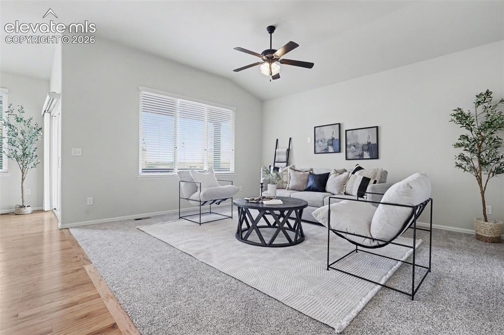 Image 7 of 39: Living area featuring a vaulted ceiling and a ceiling fan with integrated l