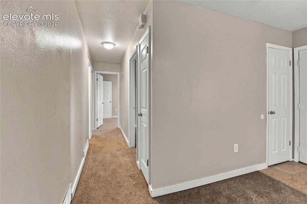 Image 11 of 34: Hallway and secondary bedroom featuring neutral wall finishes, recessed cei