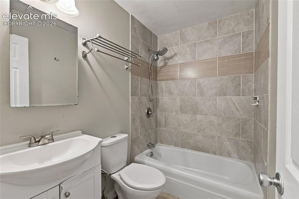 Image 16 of 34: Bathroom with a white vanity sink, brushed nickel faucet, wall-mounted mirr
