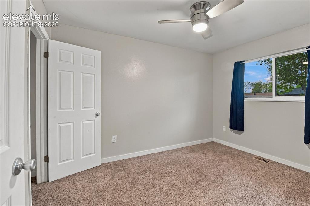 Image 21 of 34: Main level secondary bedroom or home office with a ceiling fan with integra