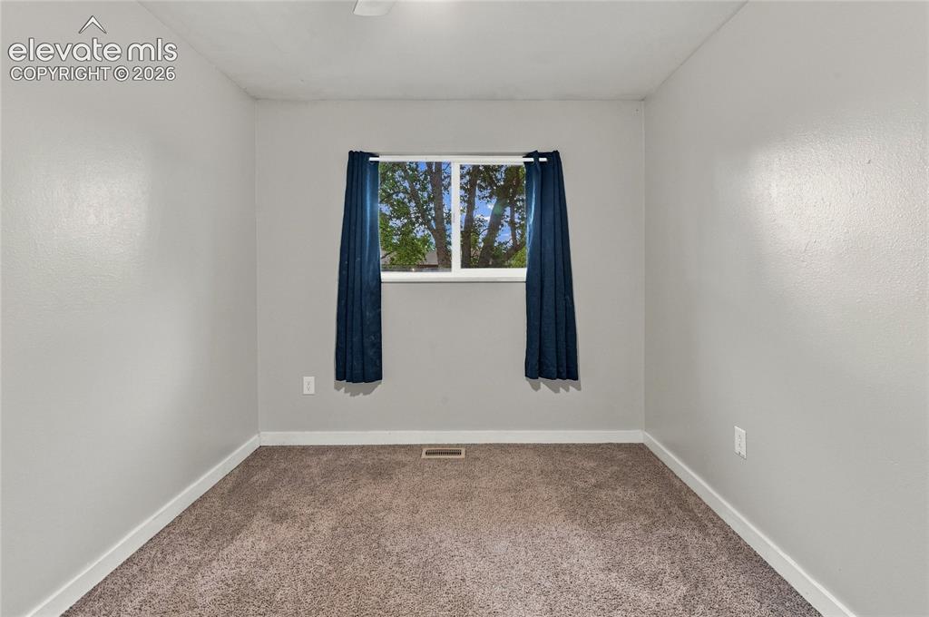 Image 22 of 34: Main level secondary bedroom or home office with a ceiling fan with integra