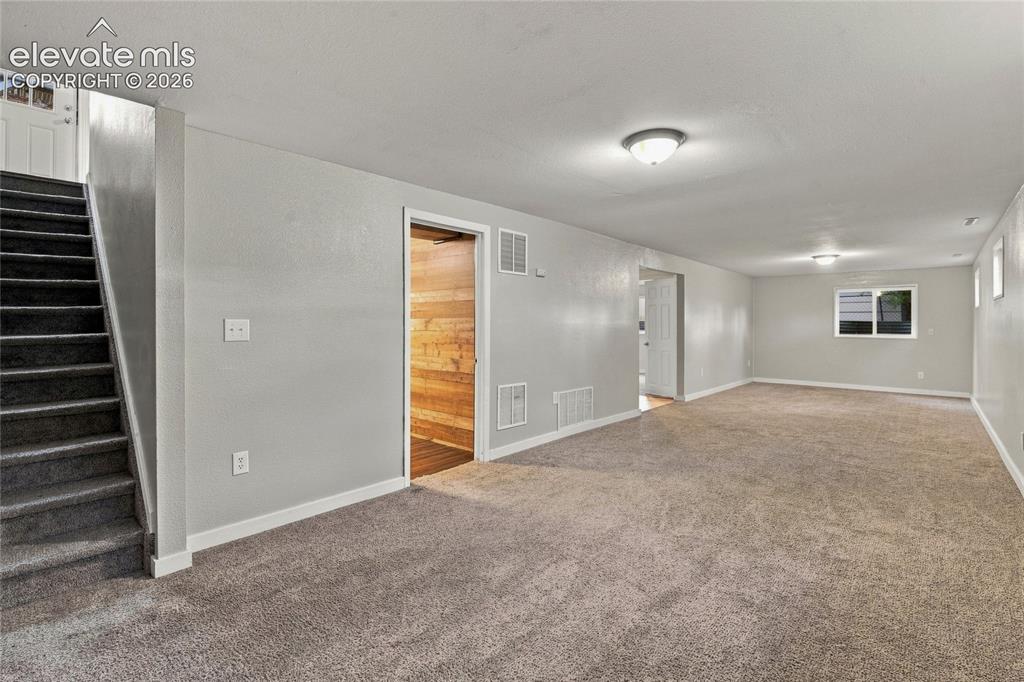 Image 24 of 34: Huge basement area with carpeted flooring throughout, recessed window, whit