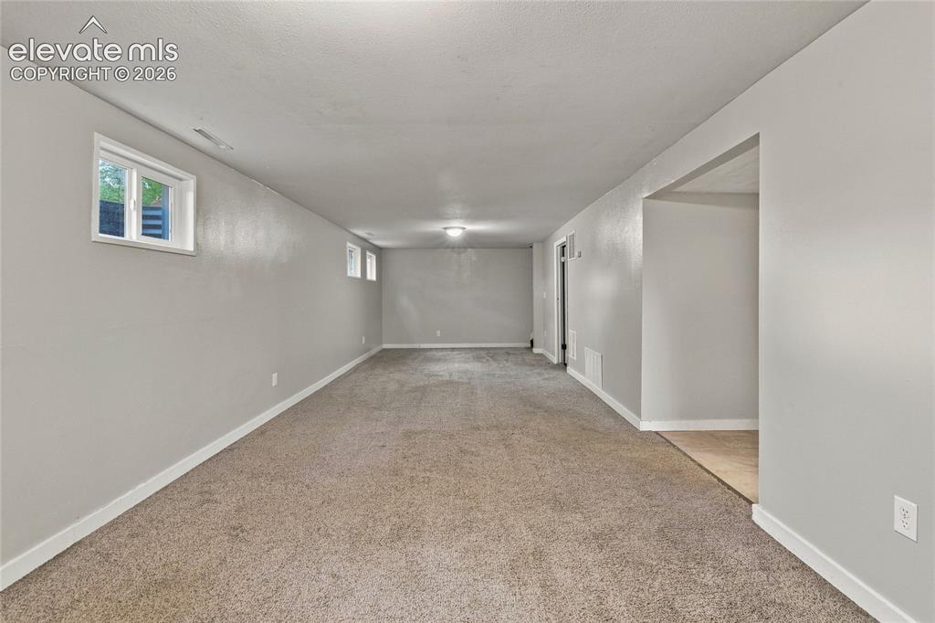 Image 25 of 34: Recessed lighting, light gray wall paint, white trim, light brown carpet, a