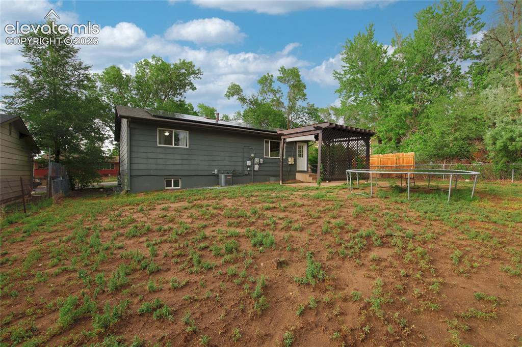 Image 33 of 34: Spacious rear grounds with mature tree-lined perimeter and established vege