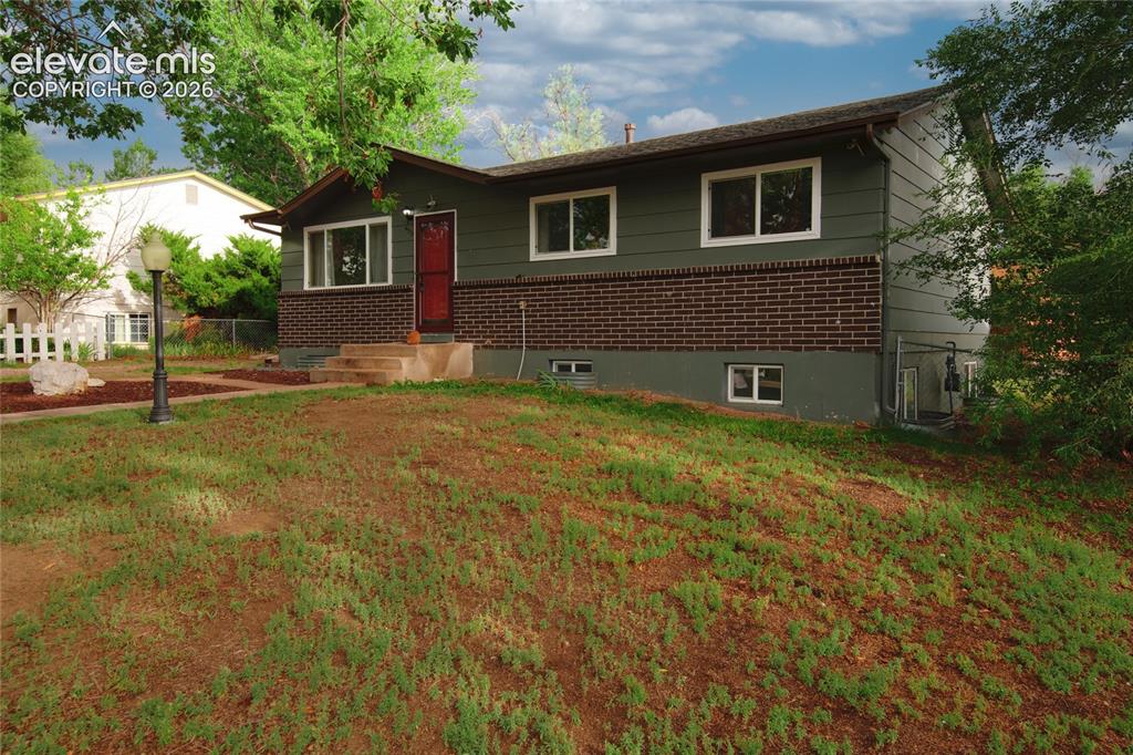Image 4 of 34: Welcoming brick ranch home featuring a concrete walkway, mature landscaping
