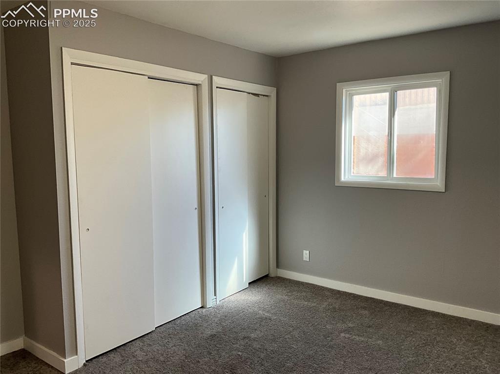 Image 11 of 41: Unfurnished bedroom featuring new carpet flooring and two closets