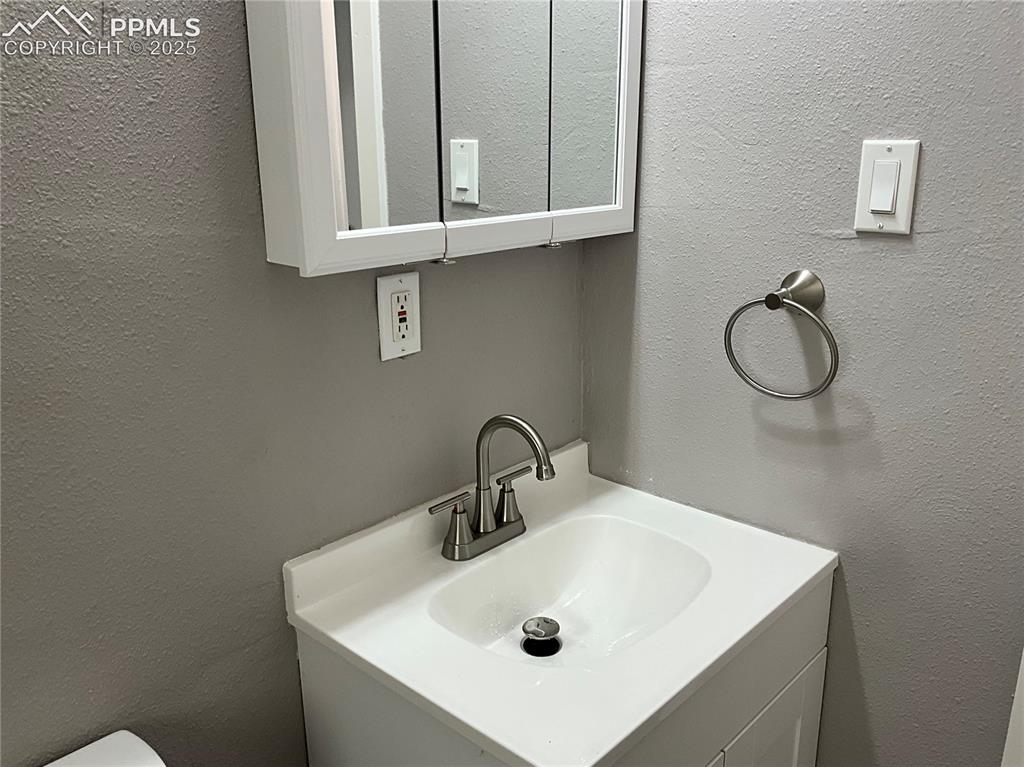 Image 16 of 41: Bathroom featuring a textured wall and vanity