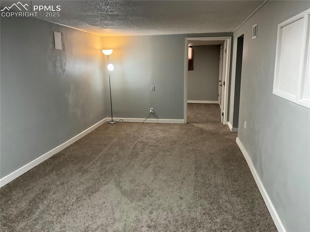 Image 22 of 41: Spare room with new carpet floors and a textured ceiling