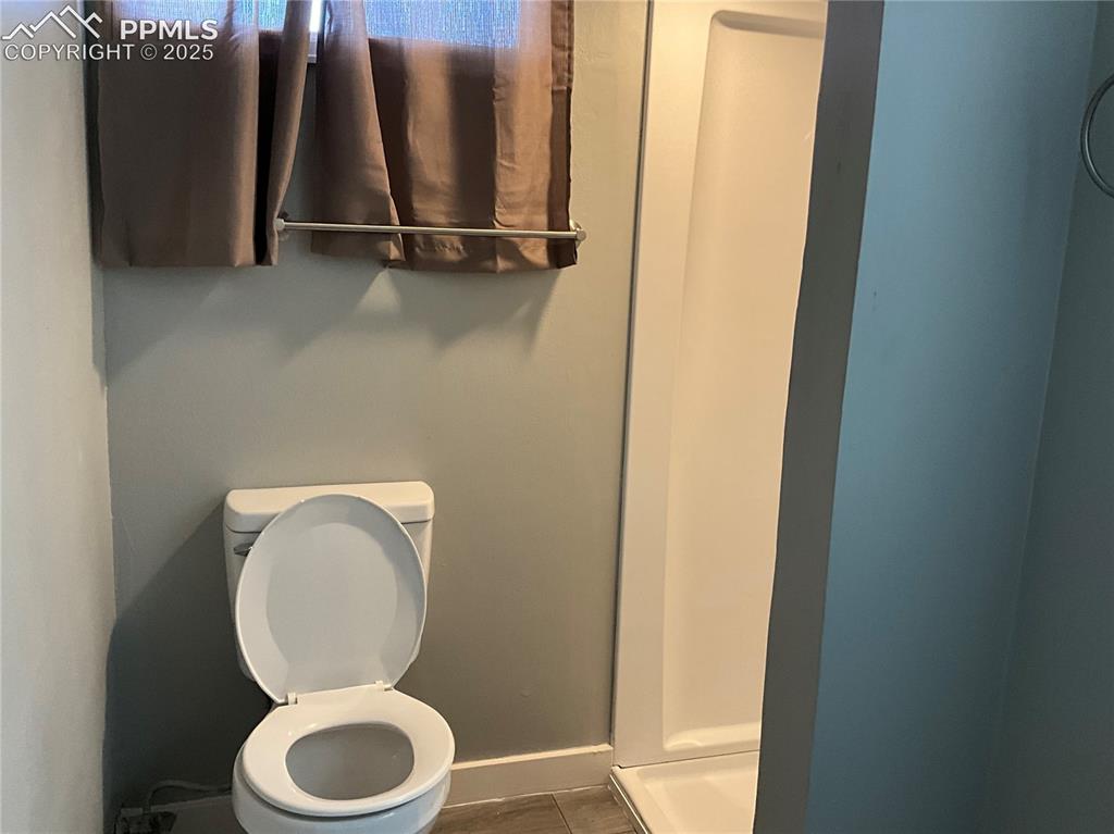 Image 30 of 41: Bathroom with toilet and a shower stall