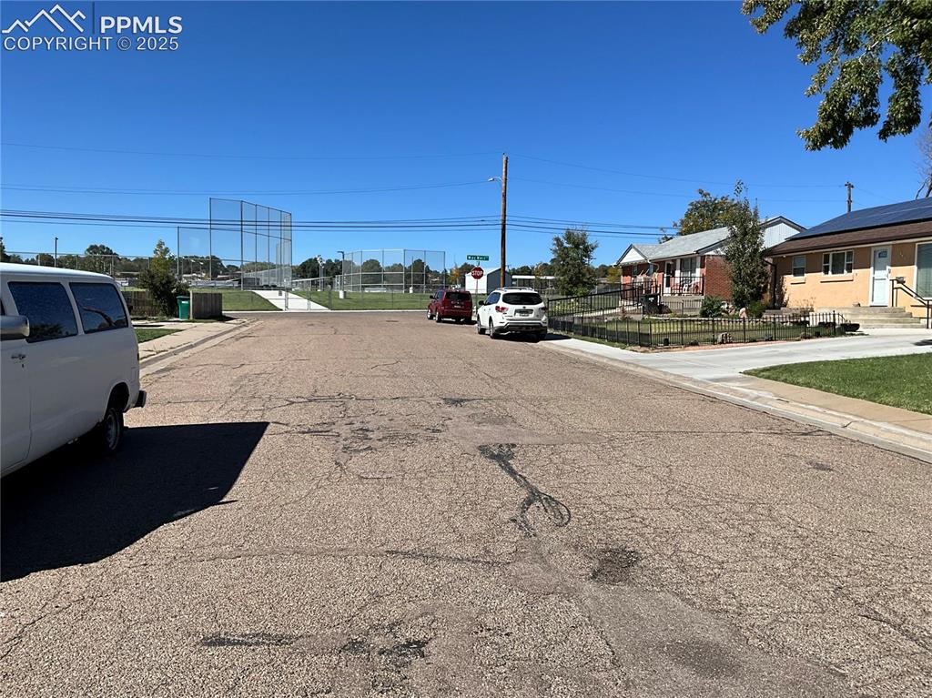 Image 33 of 41: View of asphalt road featuring sidewalks, curbs, and a residential view