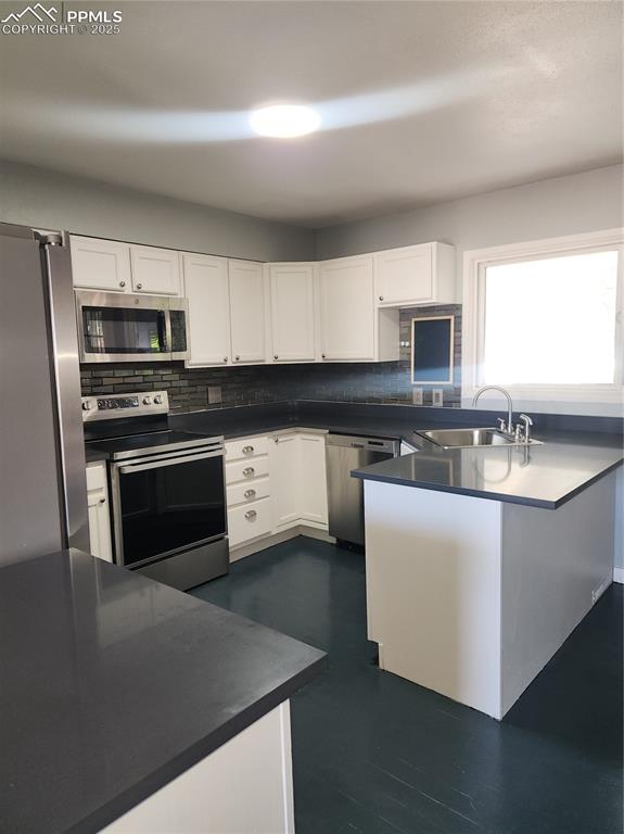 Image 9 of 43: Kitchen featuring new range oven, decorative backsplash, white cabinetry, f