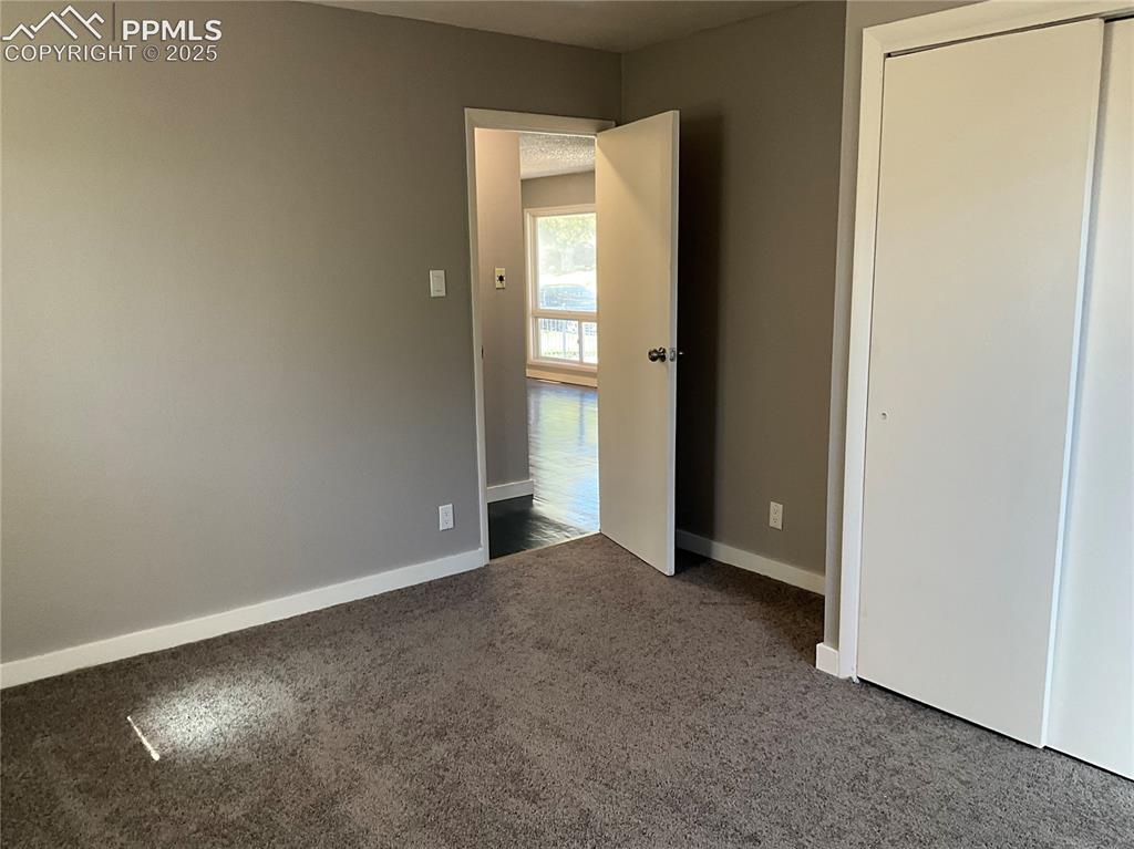 Image 9 of 41: Unfurnished bedroom featuring dark colored carpet and a closet