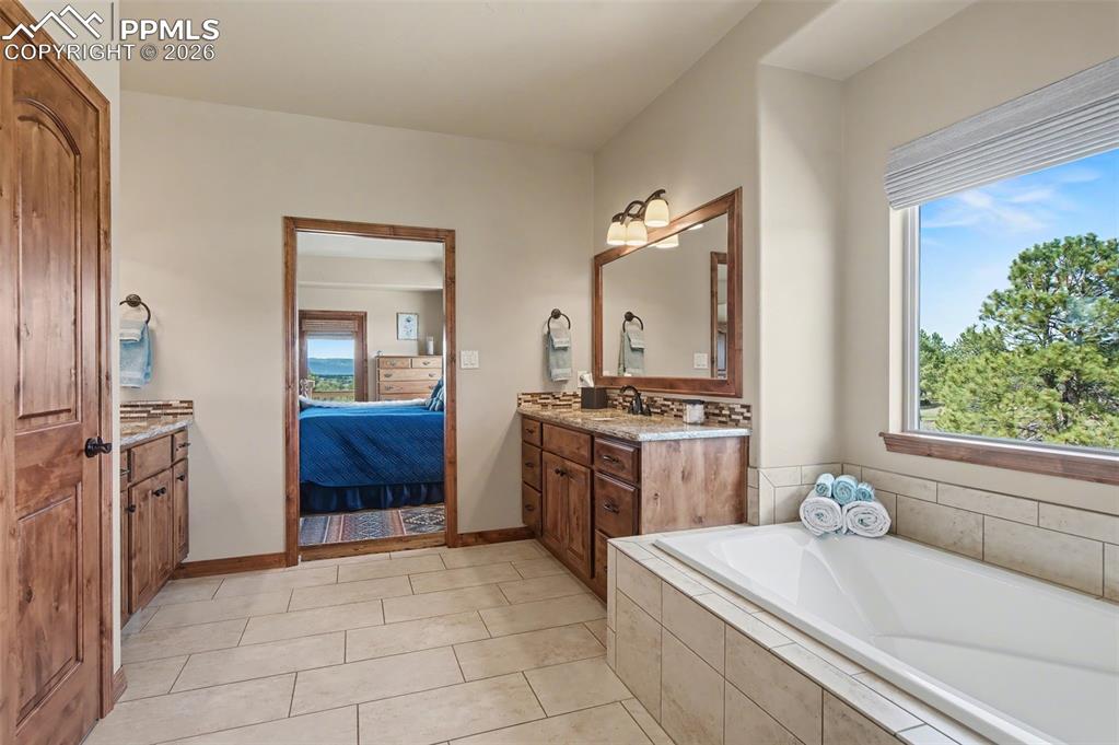 Image 19 of 49: Retreat to the spacious primary suite featuring gorgeous mountain views, wa