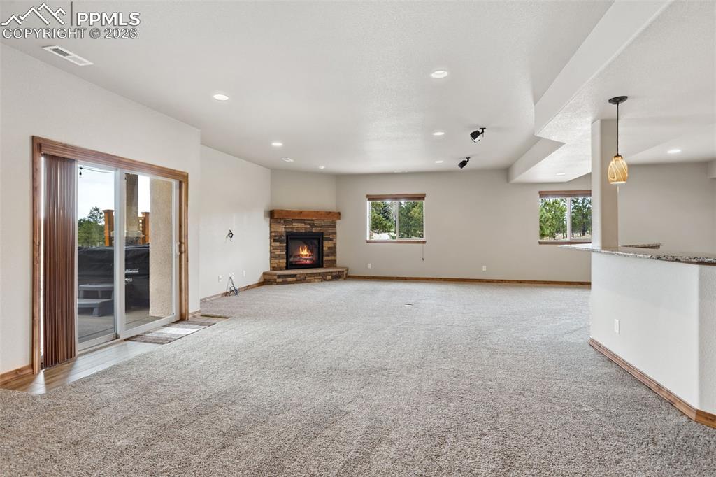 Image 36 of 49: Back in the main house, the massive family room features a wet bar, cozy fi