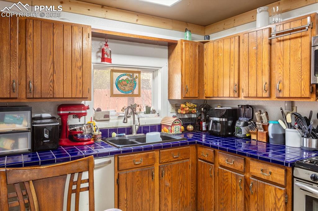 Image 14 of 45: Kitchen featuring a sink and brown cabinetry