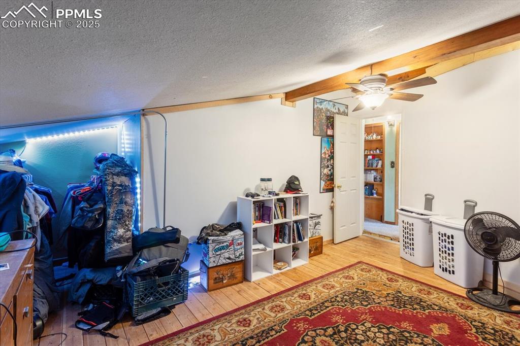Image 26 of 45: Below grade area featuring wood finished floors, a textured ceiling, and a 