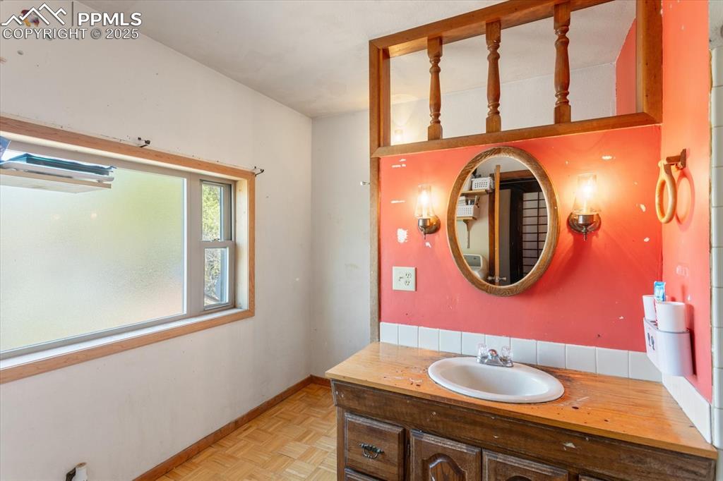 Image 29 of 45: Bathroom with vanity and baseboards