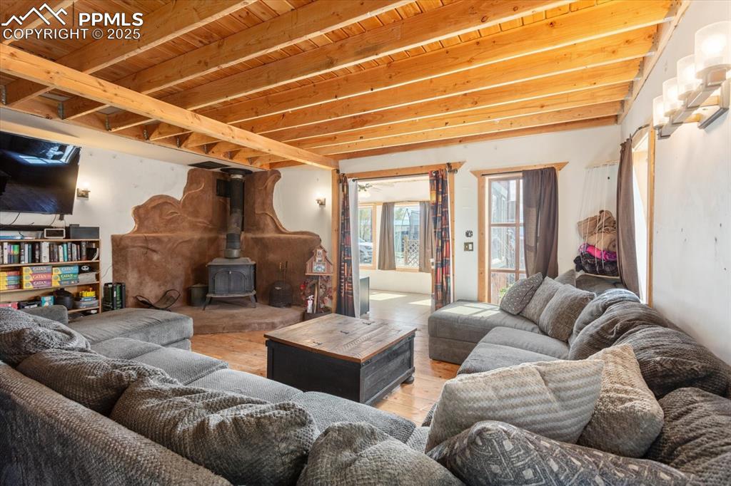 Image 9 of 45: Living area with a wood stove and light wood finished floors