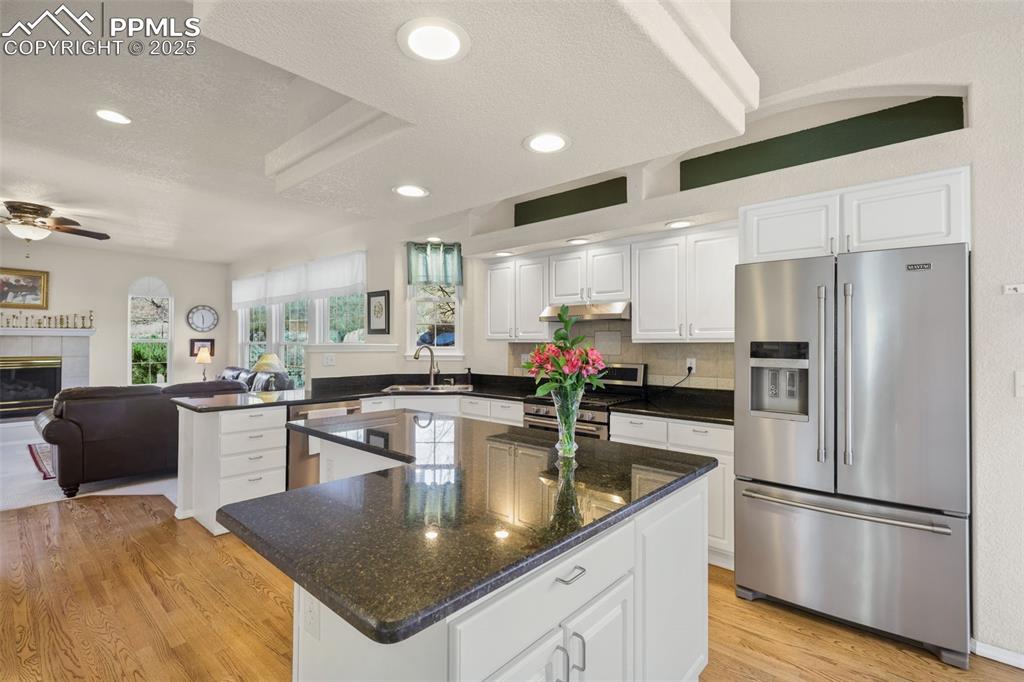 Image 11 of 49: Kitchen with appliances with stainless steel finishes, white cabinets, open