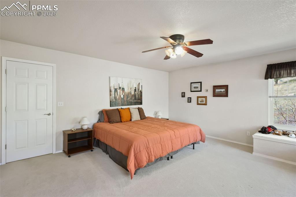 Image 23 of 49: Bedroom with carpet flooring and a ceiling fan