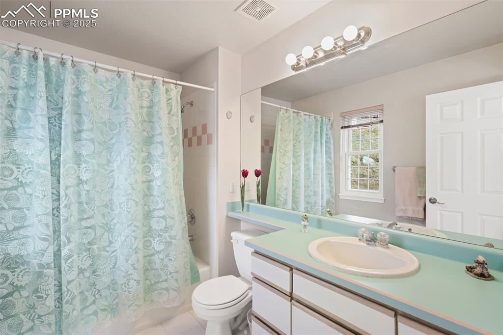 Image 28 of 49: Full bath featuring shower / bath combo, vanity, and light tile patterned f