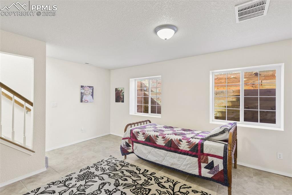Image 31 of 49: Bedroom with a textured ceiling and baseboards