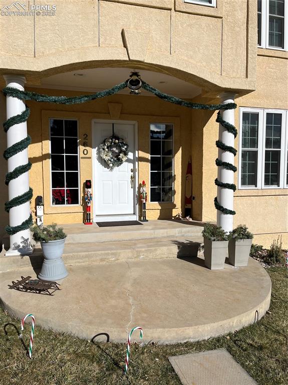 Image 42 of 49: View of exterior entry featuring a porch and stucco siding