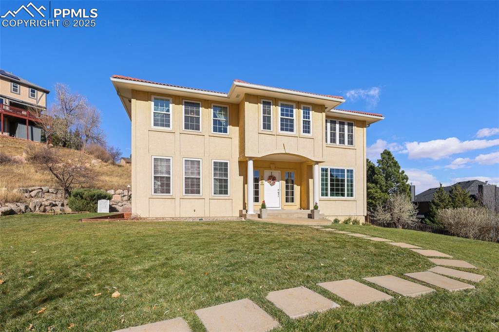 Image 47 of 49: View of front of property with a front yard and stucco siding